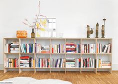 a book shelf filled with lots of books on top of a hard wood floor