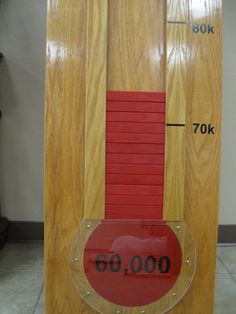 a wooden clock with red numbers on it