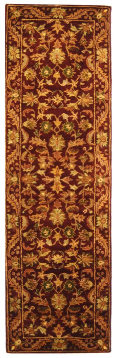 a red and gold rug with an intricate design on the bottom, in front of a white background