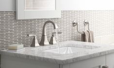 a bathroom sink with two faucets and soap dispensers on the counter