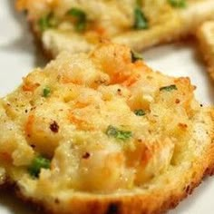 four pieces of bread with cheese and vegetables on them sitting on a white plate, ready to be eaten