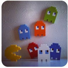 four different colored pacman magnets sitting on top of a white table next to each other