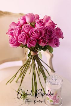 a bouquet of pink roses sitting on top of a table next to a jar of deodorant