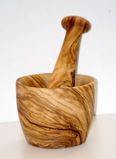 a wooden mortar and pestle set on a white surface