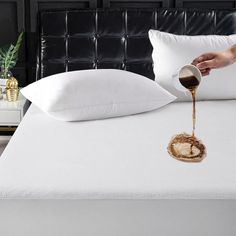 someone is pouring syrup on a bed with white pillows