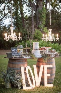 an image of a table in the grass with candles on it and love spelled out