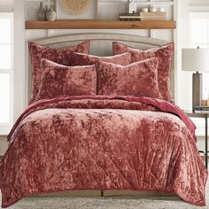 a bed with red comforters and pillows in a room