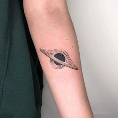 a man's arm with a saturn tattoo on it