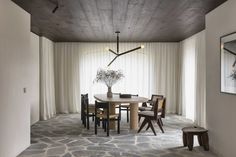 a dining room with a table and chairs next to a wall mounted light that is hanging from the ceiling