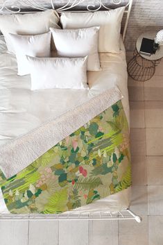 an overhead view of a bed with white pillows and blankets on top of it,