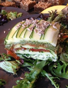 a close up of a sandwich on a plate with lettuce and other vegetables