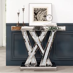 a glass and metal console table with a clock on the wall behind it, in a living room