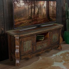 an old wooden entertainment center with a painting on the wall and cactus in front of it