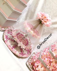 pink and white flowers are on the table next to wedding shoes, purses and jewelry