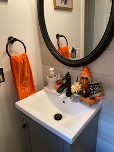 a bathroom sink sitting under a mirror next to a black and white wall mounted faucet