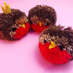 two stuffed birds with crowns on their heads sitting next to each other in front of a pink background