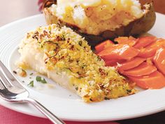 a white plate topped with potatoes and carrots next to a slice of fish pie