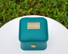 a small blue box sitting on top of a white table next to some green plants