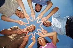 a group of people standing in a circle with their hands together and making the shape of a star