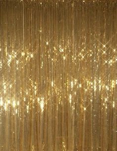 gold sequin curtain with stars and sparkles on the top, in front of a black background