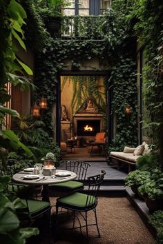 an outdoor dining area with tables and chairs in front of a fireplace surrounded by greenery