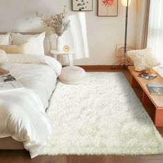 a bedroom with white bedding and pictures on the wall