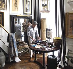 two people standing in front of a table with pictures on it