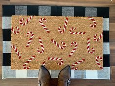 a person standing on the floor in front of a door mat with candy canes