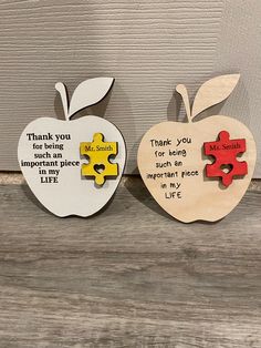 two pieces of wood with words on them and an apple shaped like a puzzle piece