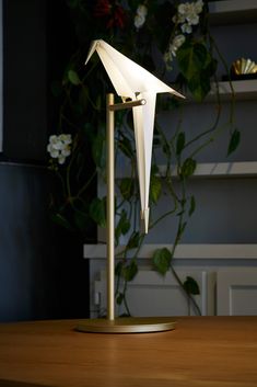 a white bird lamp sitting on top of a wooden table