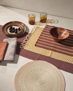 a table topped with plates and bowls filled with food next to glasses on top of a table