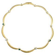 This exquisite emerald and diamond scalloped choker necklace is masterfully crafted in 18 karat yellow gold. This luxurious piece features a stunning design with alternating vibrant emeralds and dazzling diamonds. The choker’s unique scalloped pattern is enhanced by the alternating textures of gold. The high polished finish provides a sophisticated backdrop for the gems, while the Florentine sections offer an intricate textured surface, creating a striking contrast. Striking green emeralds and s Luxury Round Choker, Luxury Gold Fine Jewelry Choker, Luxury Yellow Gold Choker With Adjustable Chain, Luxury Yellow Gold Formal Choker, Elegant Luxury Yellow Gold Choker, Luxury Vintage Gold Choker, Collar Necklace Choker, Choker Diamond, Gold Link Necklace