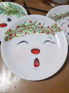 three plates with faces painted on them sitting on a table