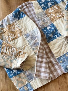 a blue and white quilt laying on top of a wooden floor