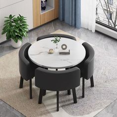 a white table with two black chairs and a potted plant