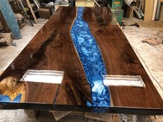 a table made out of wood with blue paint on the top and bottom, sitting in a shop