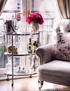 a chair sitting in front of a window filled with bottles and glasses