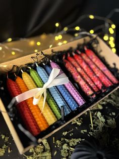 a box filled with lots of different colored candles