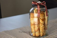 a jar filled with bread sticks sitting on top of a table next to a striped cloth