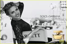 a woman is holding a bag and posing for a magazine advert with the caption dolce & garbana