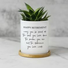 a potted plant sitting on top of a white counter next to a sign that says happy retirement