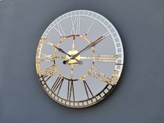 a gold and white clock with roman numerals against a gray background, showing the time