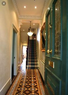 a long hallway with stairs leading up to the door and light fixture on the ceiling