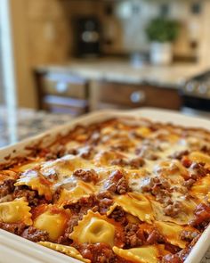 a casserole dish with meat and cheese in it sitting on a kitchen counter