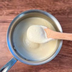 a wooden spoon in a metal cup filled with cream