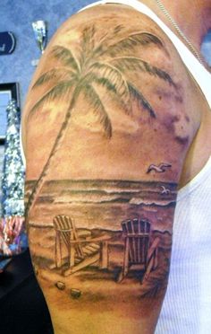 a man's arm with a palm tree and chairs on the beach