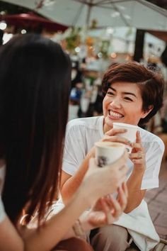 two women sitting down talking and drinking coffee