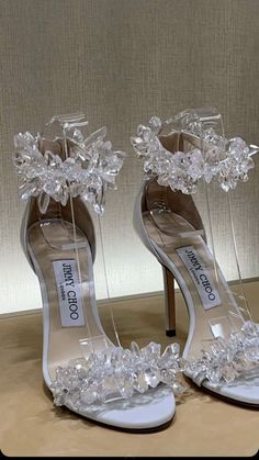 a pair of high heeled shoes with flowers and crystals on the toes are shown