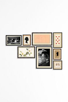 a white wall with many framed pictures on it