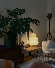 a living room filled with furniture and a lamp on top of a wooden table next to a white couch